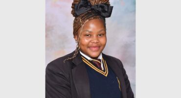 a girl in a school uniform with a black and yellow stripe tie