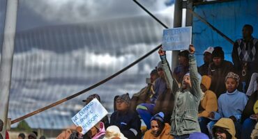 people hold up posters on a pavilion