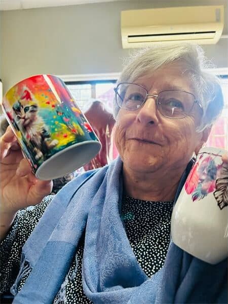 a woman holds up two mugs