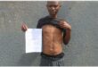 man with a paper and bullet wounds in his stomach