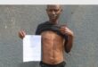 man with a paper and bullet wounds in his stomach