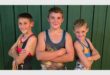 three boys in wrestling outfits