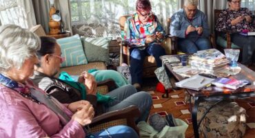 a group of women crocheting in a a lounge