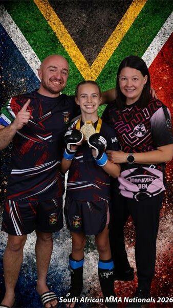 two parents and their child in front of the South African flag