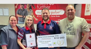 two women and two men with a certificate and a large cheque