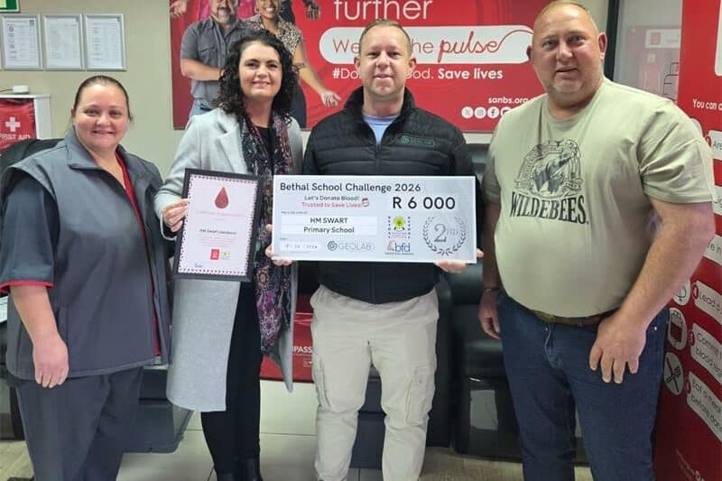 two women and two men with a certificate and a large cheque