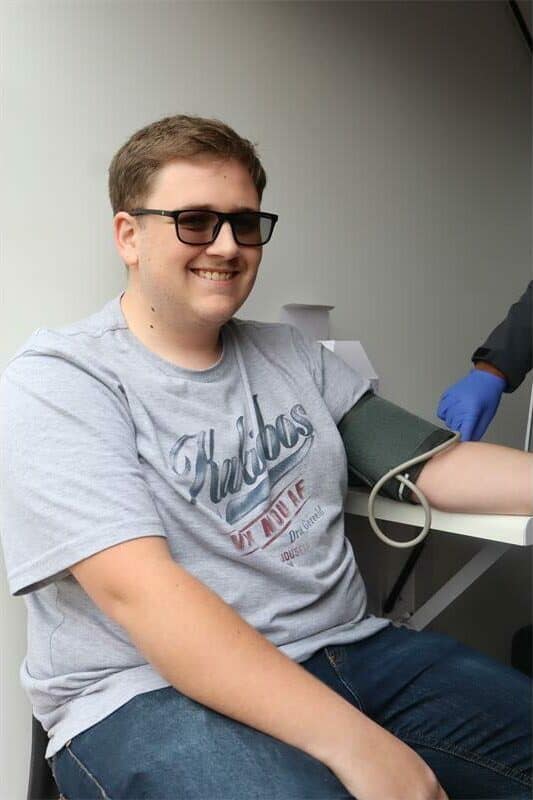 a young man with a moustache and wearing a t shirt is testing his blood pressure