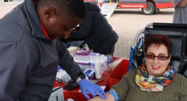 a nurse looks for a vein on a blood donor's arm