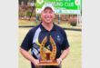 man in blue sports wear holds up a trophy