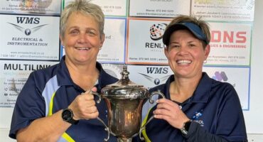 Two women hold up a trophy