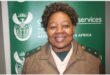 woman in correctional services uniform standing in front of a green backdrop