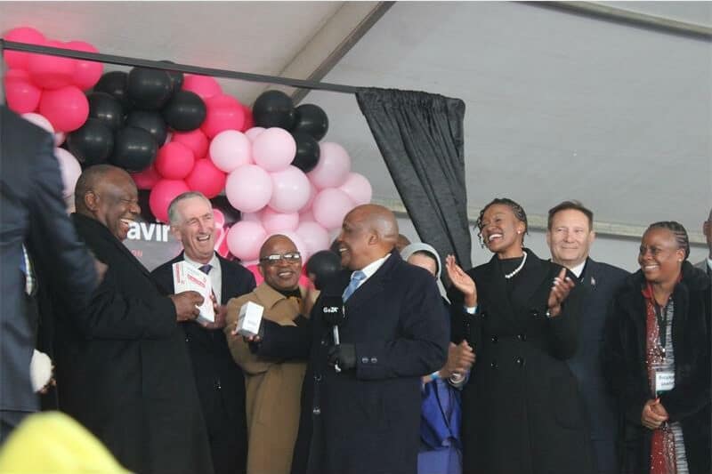 a group of men in suits with balloons in the background