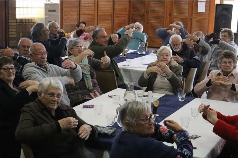 elderly people sitting around tables