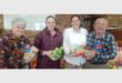 people holding up donated groceries