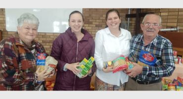 people holding up donated groceries