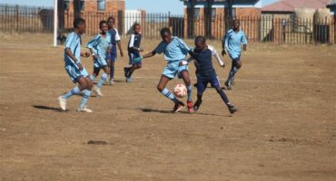 two teams of young soccer players compete for the ball.