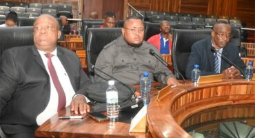 people sitting in a council chamber
