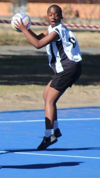 netball teams from two schools compete for the ball