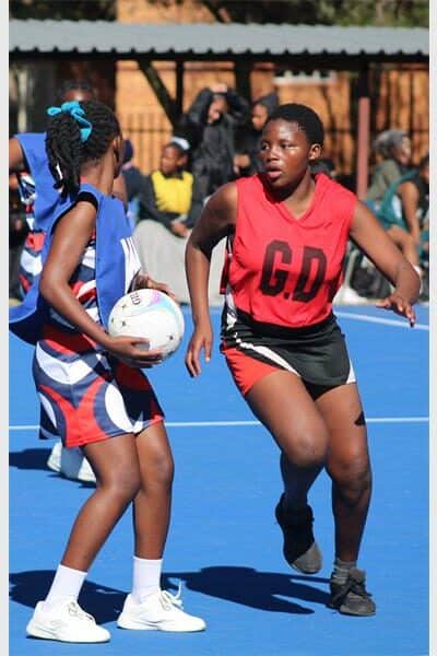 netball teams from two schools compete for the ball