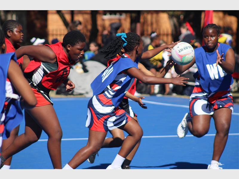netball teams from two schools compete for the ball