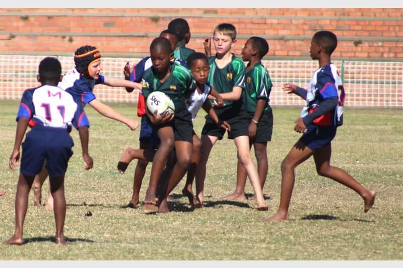 Two teams of young rugby players compete