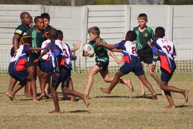Two teams of young rugby players compete