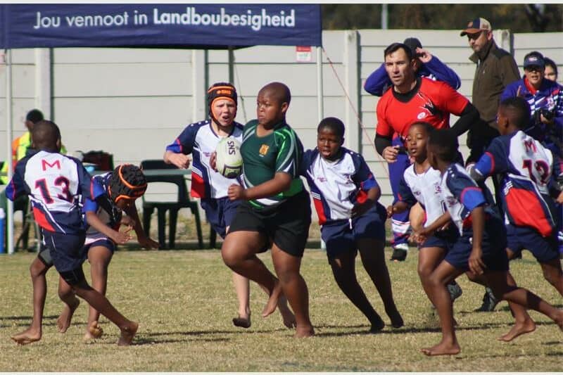 Two teams of young rugby players compete