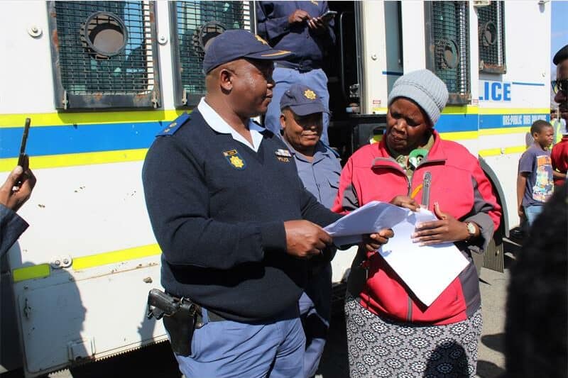 a policeman receives a memorandum from a woman