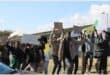 people picket with posters outside the court