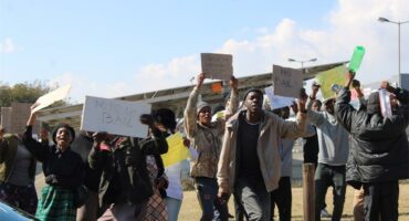 people picket with posters outside the court