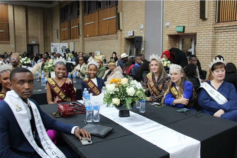 beauty queens sit around a table