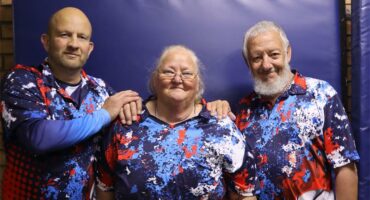 Two men and a woman in blue, red and white sport shirts