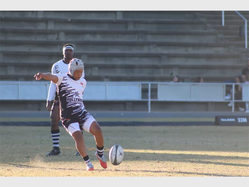 a rugby match between players in black and blue and a team in white and black.