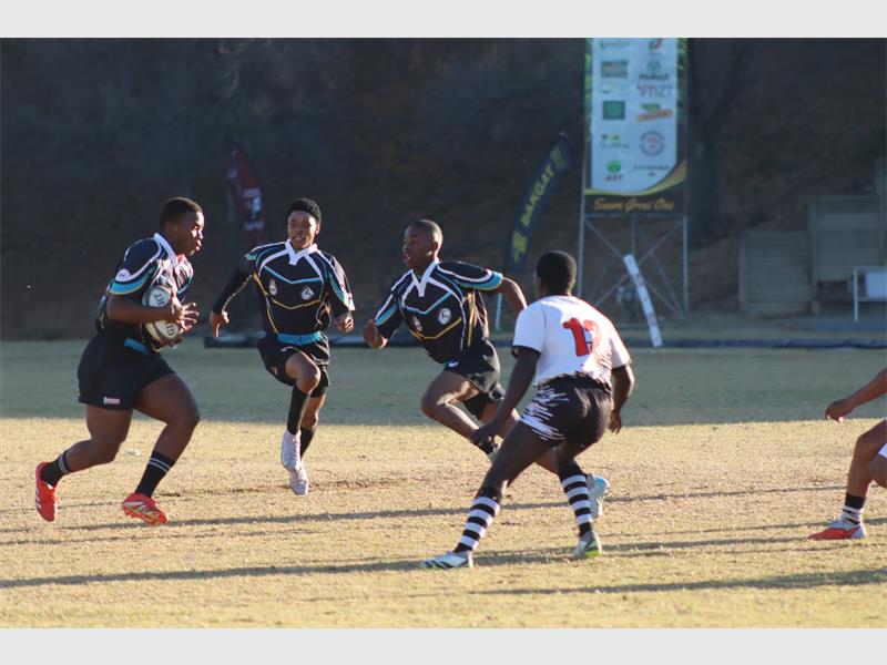 a rugby match between players in black and blue and a team in white and black.