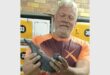 man is holding up homing pigeon