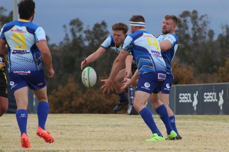 rugby players for two teams compete for the ball