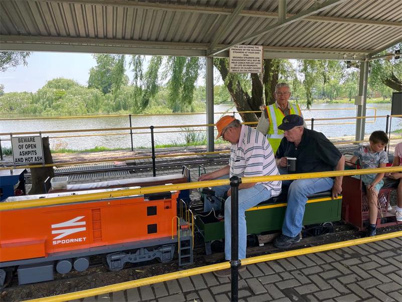 people working on a miniature steam engine