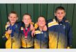 four boys with tracksuits and medals