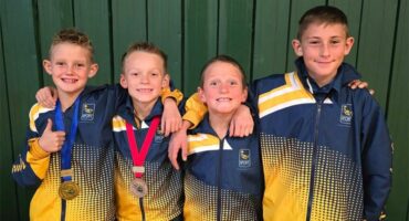 four boys with tracksuits and medals