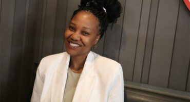 smiling woman wearing a white suit jacket