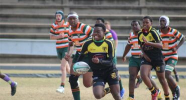 a boy in black and yellow rugby jersey runs at full speed
