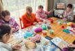 women sitting around a table knitting