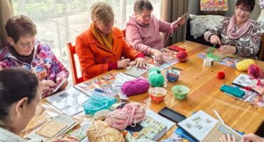women sitting around a table knitting