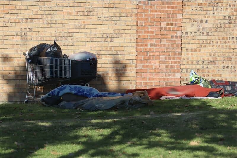 Vagrants camp against a boundary wall