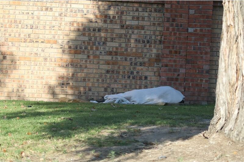 A vagrant sleeping under a duvet in town