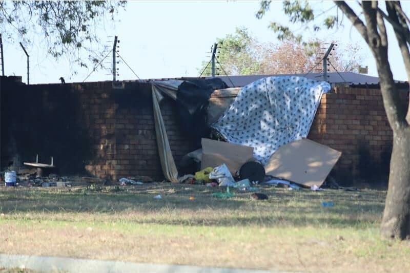 Vagrants camp against a boundary wall