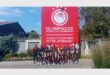 A team posing in front of a huge banner