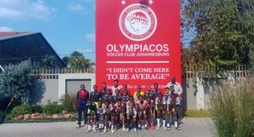 A team posing in front of a huge banner