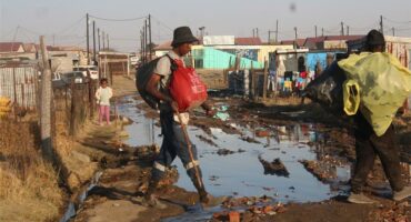 a man steps over a stream of sewage
