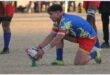 A rugby player sets the ball for a conversion kick